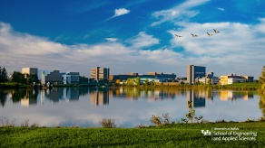 Background 6: University at Buffalo North Campus academic buildings from across Lake LaSalle on a sunny day with the School of Engineering and Applied Sciences logo in the bottom right corner. 