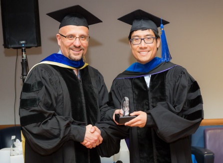 Zoom image: PhD candidate in commencement regalia. 