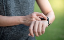 Personal touching a smart watch on their wrist. 