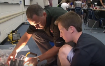 Student and camp leader work on project. 