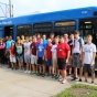 group photo of campers in front of a UB Stampede bus. 