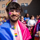 Student with pride flags at UB pride parade. 
