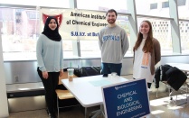 Zoom image: Members of the American Institute of Chemical Engineers (AIChE) UB chapter at a student club fair in Davis Hall. 