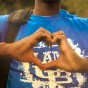 Student wearing a UB t-shirt making a heart with their hands. 