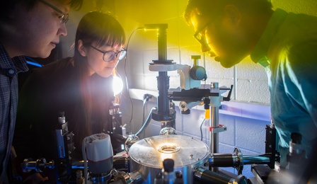 Lab of Jung-Hun Seo as he works with two students looking over a project. 