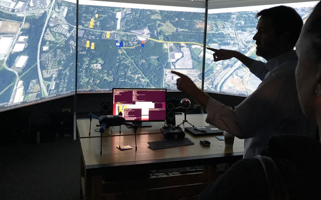 Faculty member views a map on the screen in the optimator lab. 