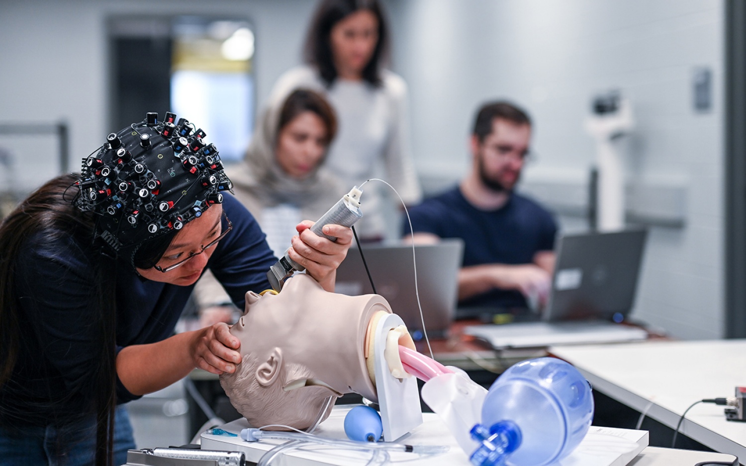 Students and faculty run tests in healthcare lab. 
