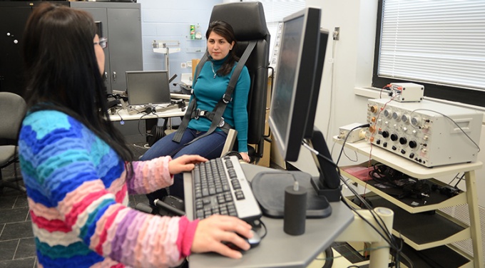 photo of two graduate students working in an ISE lab on workplace safety research. 