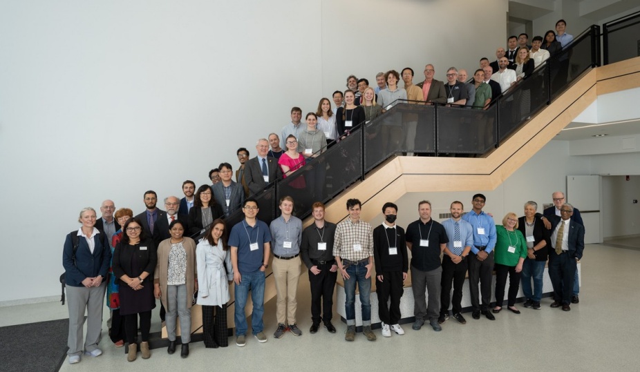 A group of symposium attendees pose together on a staircase in Capen Hall. 