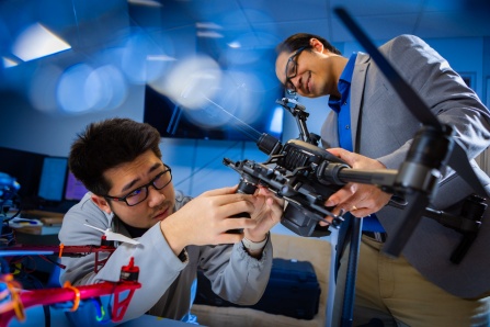 UB faculty and grad student working on drones in the lab. 