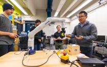 Chaozhe He meets with students in a research lab space in Furnas Hall. 