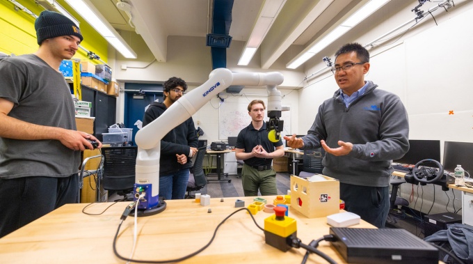 Chaozhe He meets with students in a research lab space in Furnas Hall. 