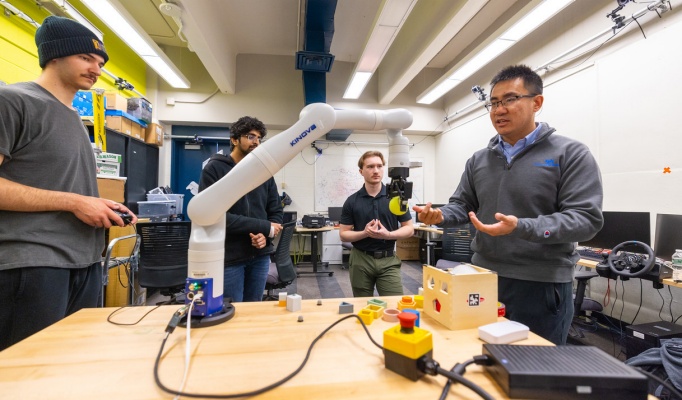 Chaozhe He meets with students in a research lab space in Furnas Hall. 