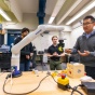 Chaozhe He meets with students in a research lab space in Furnas Hall. 