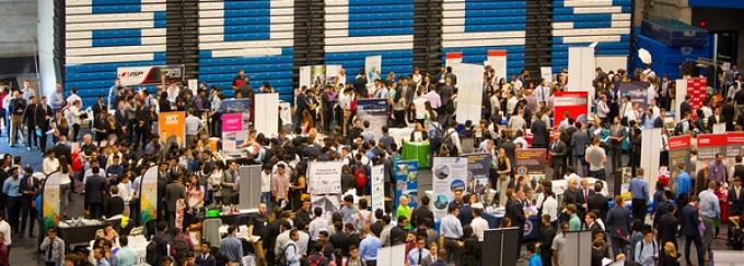 Career Fair depicting many tables, employers and students. 